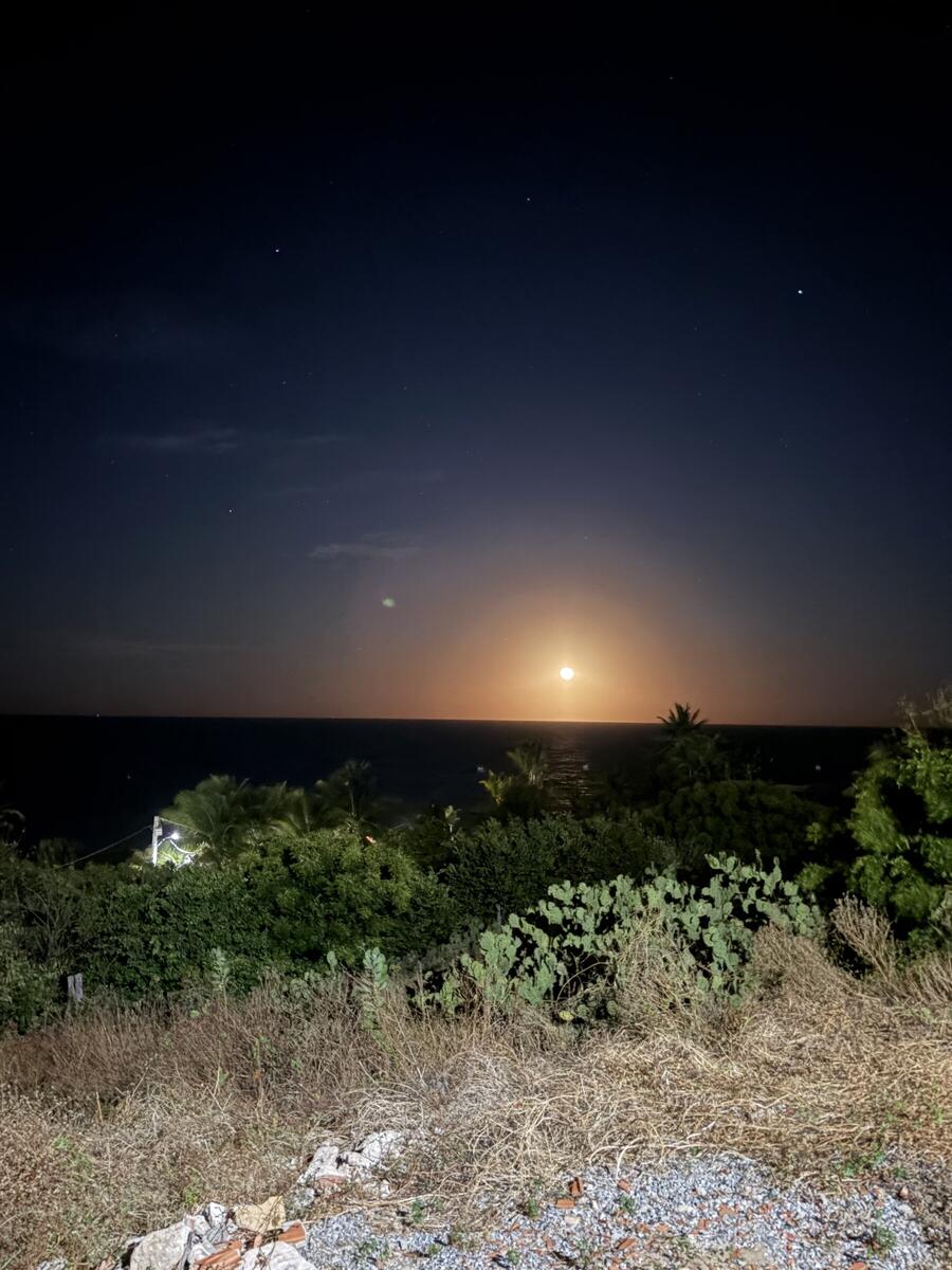 A lua cheia nascendo laranja no mar de Quixaba